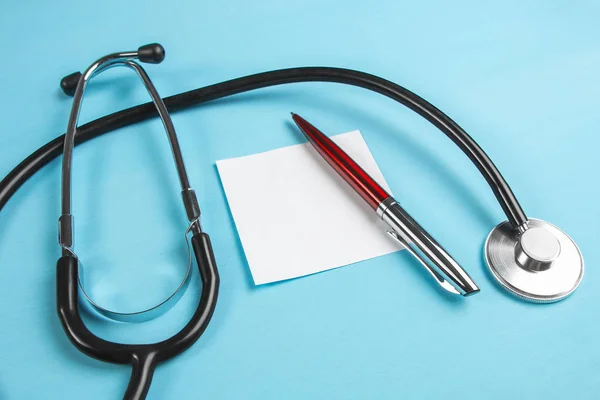 Mavi bac üzerinde kırmızı saplı ve stetoskoplu beyaz kağıt