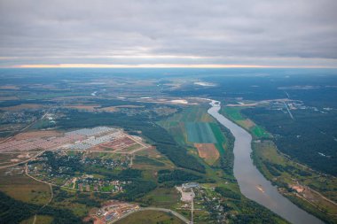 Sis, nehir, tarlalar ve ormandaki akşam kenti manzarası