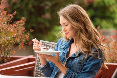 Güzel kadın bir teras pasta yemeye