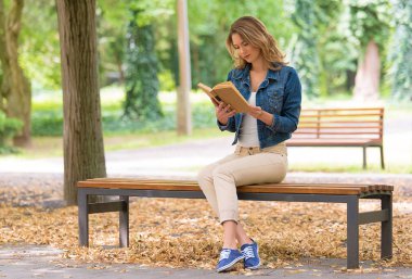 Güzel kadın parkta eski bir kitap okumak