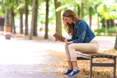 Güzel kadın parkta eski bir kitap okumak