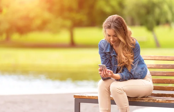 Young Woman Sitting Bench Use Her Phone Park — Stock Photo, Image