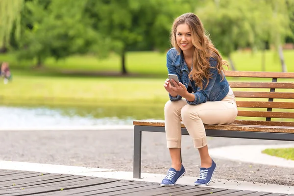 Mujer Joven Sentada Banco Usando Teléfono Parque — Foto de Stock