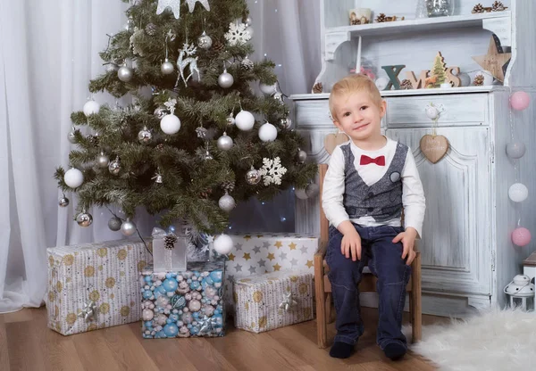 Entzückendes Kind Auf Stuhl Sitzend Der Nähe Des Weihnachtsbaums — Stockfoto