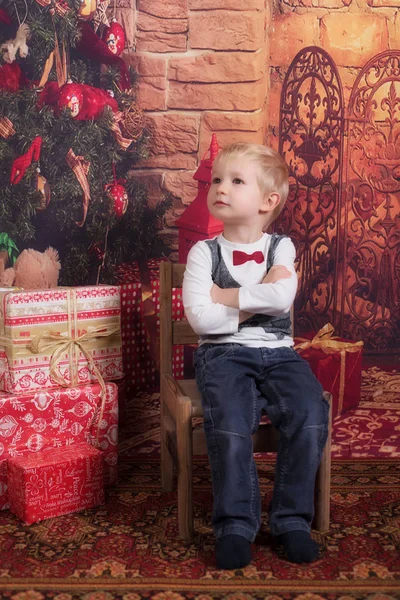 Очаровательный Ребенок Сидит Стуле Возле Рождественской Елки — стоковое фото