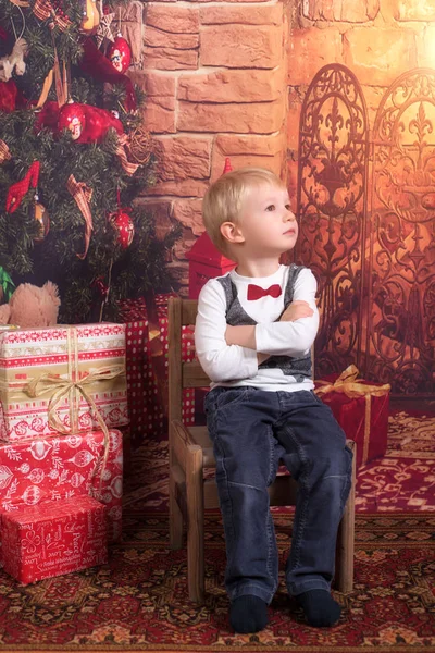 Очаровательный Ребенок Сидит Стуле Возле Рождественской Елки — стоковое фото