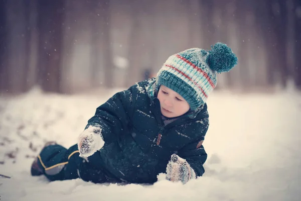Young boy play in the snow a winters day