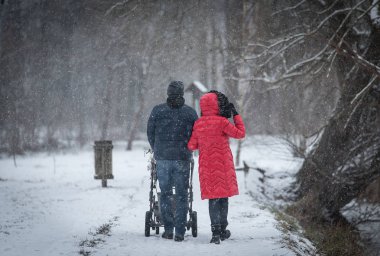 Genç çift bebek kış parkta yürüyüş