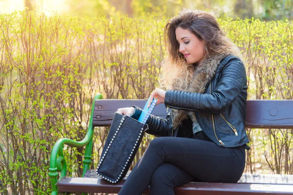 Mujer buscando algo en su bolso —  Fotos de Stock