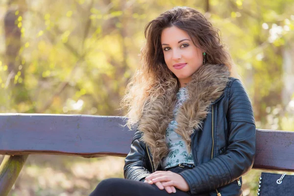 Hermosa mujer descansando un banco en el parque — Foto de Stock