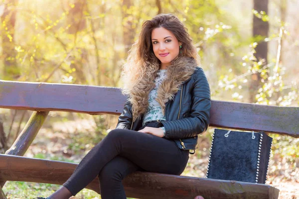 Hermosa mujer descansando un banco en el parque — Foto de Stock