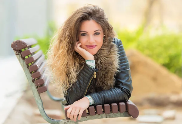 Hermosa mujer descansando un banco en el parque — Foto de Stock