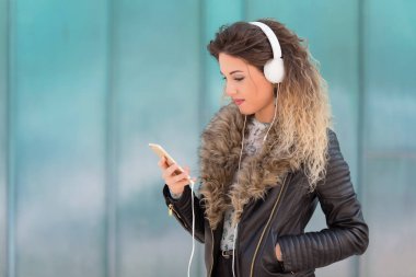 Kulaklıkla müzik dinleyen genç bir kadın.