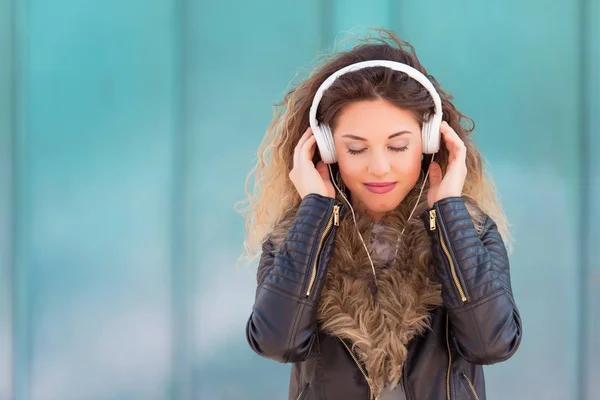 Junge Frau hört Musik mit ihren Kopfhörern Stockfoto