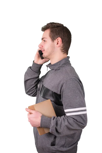 Hombre guapo usando un teléfono inteligente y sosteniendo un libro viejo sobre fondo blanco — Foto de Stock