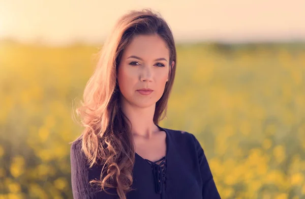Retrato de mujer hermosa en campo de colza — Foto de Stock