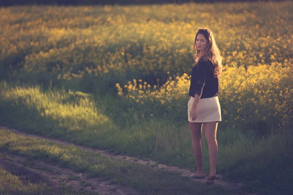 Hermosa mujer caminando en campo de colza . —  Fotos de Stock