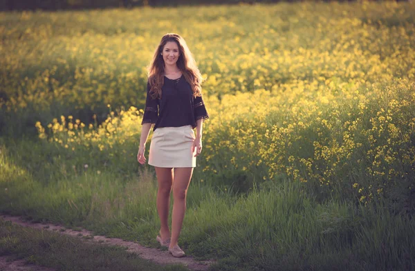 Mulher bonita andando no campo de colza . — Fotografia de Stock