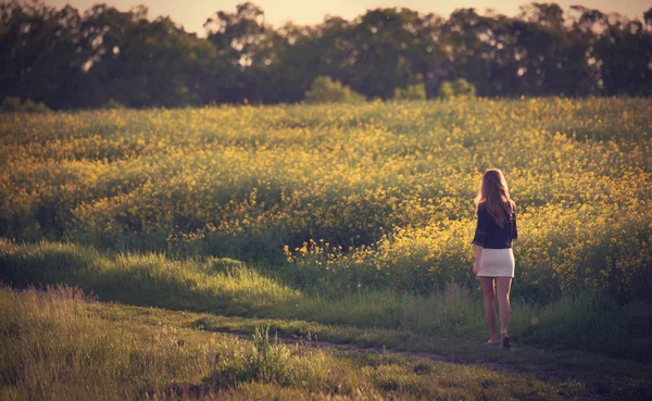 Belle femme marchant dans le champ de colza . — Photo