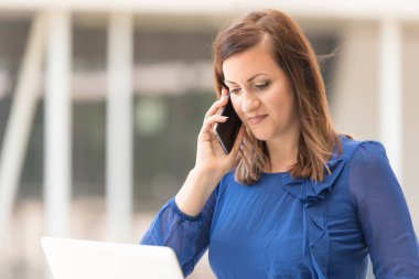 Güzellik kadın oturma ve bir dizüstü bilgisayar kullanma