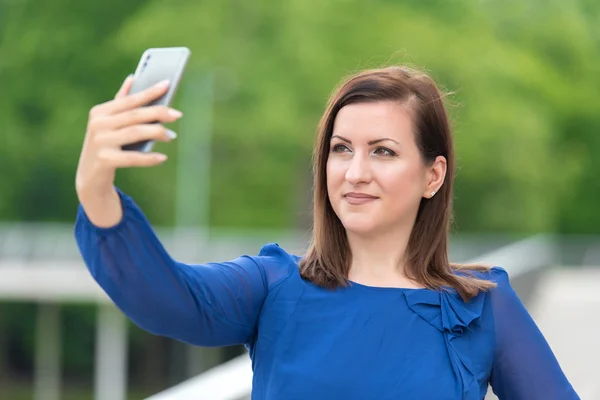 Mujer joven tomando una selfie con su teléfono — Foto de Stock