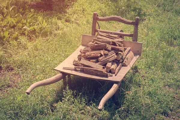 Leña en la vieja carretilla de madera —  Fotos de Stock