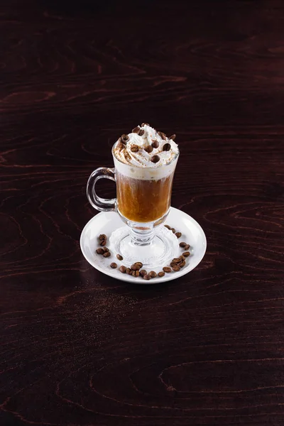 Delicious Irish coffee, hot milk, wooden table, foam, coffee beans on a wooden background