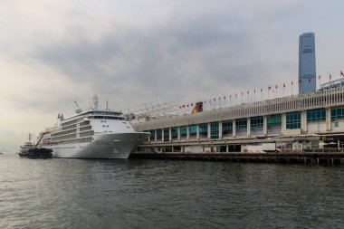 Hong Kong, Çin - 24 Mart 2015: Büyük Cruise Ship, Victoria Harbour Bording yolcu için. Victoria Limanı Hong Kong Adası ve Kowloon Hong Kong arasında yer alan bir doğal ekipman liman olduğunu