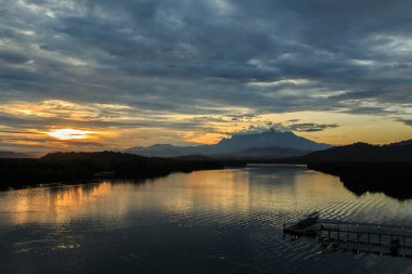 Arka plan olarak Mount Kinabalu ile bulutlu gündoğumu