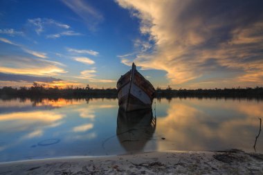 Shore, Borneo, eski balıkçı teknesinde gün batımı an yansıması ile eski batık terk