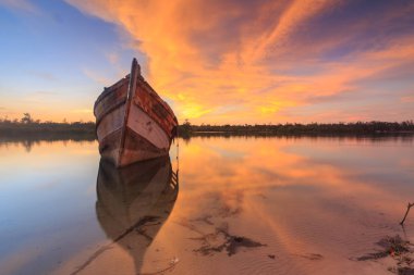 Shore, Borneo, eski balıkçı teknesinde gün batımı an yansıması ile eski batık terk