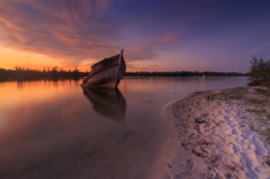 Shore, Borneo, eski balıkçı teknesinde gün batımı an yansıması ile eski batık terk