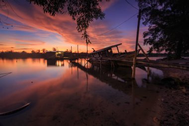 Shore, Borneo, eski balıkçı teknesinde gün batımı an yansıması ile eski batık terk