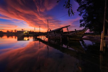 Shore, Borneo, eski balıkçı teknesinde gün batımı an yansıması ile eski batık terk