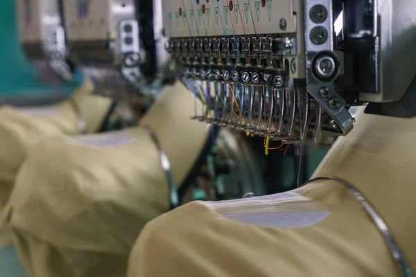 Kumaş Üreticilerinde Tekstil Endüstrisinde nakış makinesi iğnesi, nakış başlığı, iğne ipliği (seçici odaklanma ve yumuşak odaklanma))