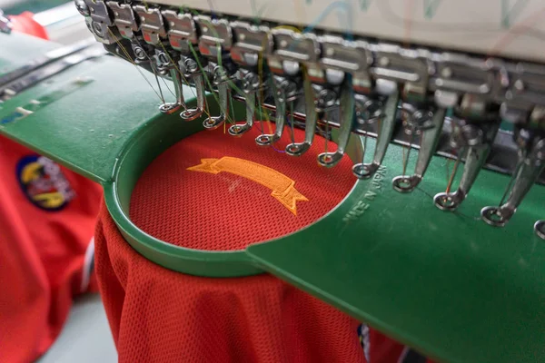 Embroidery machine needle in Textile Industry at Garment Manufacturers, Embroidery T-shirt in progress, Needle with thread (selective focus and soft focus)