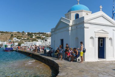 Mykonos, Yunanistan - Eylül 2017 yaklaşık: Gezginler ziyaret güzel beyaz mimari kilisenin Santorini Island, Yunanistan, güneşli ve açık mavi gökyüzü sırasında