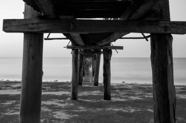 Güzel gün batımı sırasında soyut eski ahşap iskeleli iskele uzun pozlama