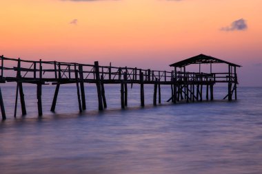 Güzel gün batımı sırasında soyut eski ahşap iskeleli iskele uzun pozlama
