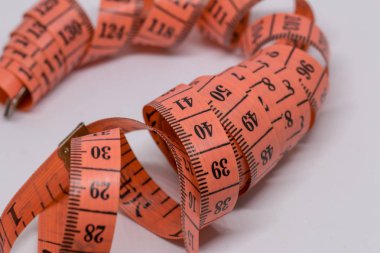 Beyaz üzerine izole edilmiş mezuranın soyut yumuşak odağı, terzi tasarımı için mezura ölçümü, fitness kullanımı için mezura ölçümü