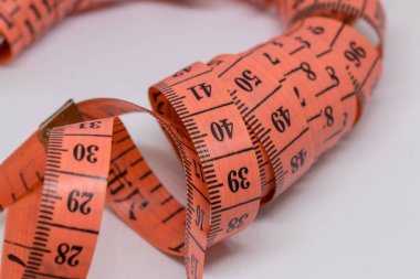 Beyaz üzerine izole edilmiş mezuranın soyut yumuşak odağı, terzi tasarımı için mezura ölçümü, fitness kullanımı için mezura ölçümü