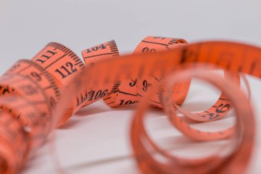 Beyaz üzerine izole edilmiş mezuranın soyut yumuşak odağı, terzi tasarımı için mezura ölçümü, fitness kullanımı için mezura ölçümü