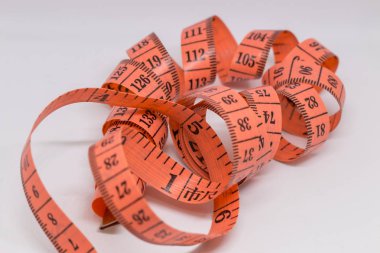 Beyaz üzerine izole edilmiş mezuranın soyut yumuşak odağı, terzi tasarımı için mezura ölçümü, fitness kullanımı için mezura ölçümü