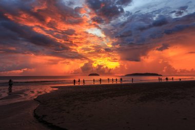 Tanjung Aru Sahili, Kota Kinabalu, Sabah, Borneo 'da siluet turisti ile güzel bir gün batımı. Tanjung aru Sahili Kota Kinabalu, Sabah, Malezya 'daki en ünlü gün batımı manzarasıdır. 