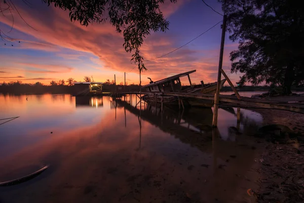 İnanılmaz Günbatımı Alacakaranlığı ahşap iskeleli ve terk edilmiş Sahildeki eski enkaz - manzara konsepti