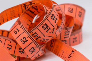 Beyaz üzerine izole edilmiş mezuranın soyut yumuşak odağı, terzi tasarımı için mezura ölçümü, fitness kullanımı için mezura ölçümü