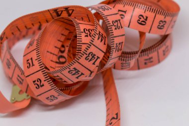 Beyaz üzerine izole edilmiş mezuranın soyut yumuşak odağı, terzi tasarımı için mezura ölçümü, fitness kullanımı için mezura ölçümü