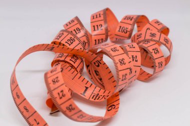 Beyaz üzerine izole edilmiş mezuranın soyut yumuşak odağı, terzi tasarımı için mezura ölçümü, fitness kullanımı için mezura ölçümü