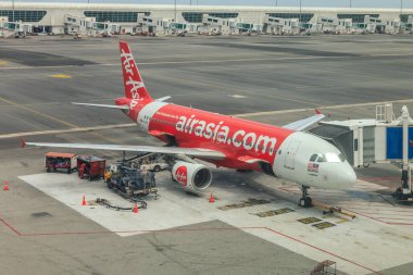 Kuala Lumpur, Malezya - 14 Mayıs 2017: İnsanlar uçağa binerken KLIA2 'ye park etmiş Air Asia Airbus uçağı. Air Asia, Malezya 'nın en ucuz havayolu şirketidir. .