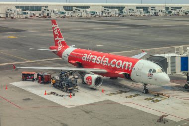 Kuala Lumpur, Malezya - 14 Mayıs 2017: İnsanlar uçağa binerken KLIA2 'ye park etmiş Air Asia Airbus uçağı. Air Asia, Malezya 'nın en ucuz havayolu şirketidir. .